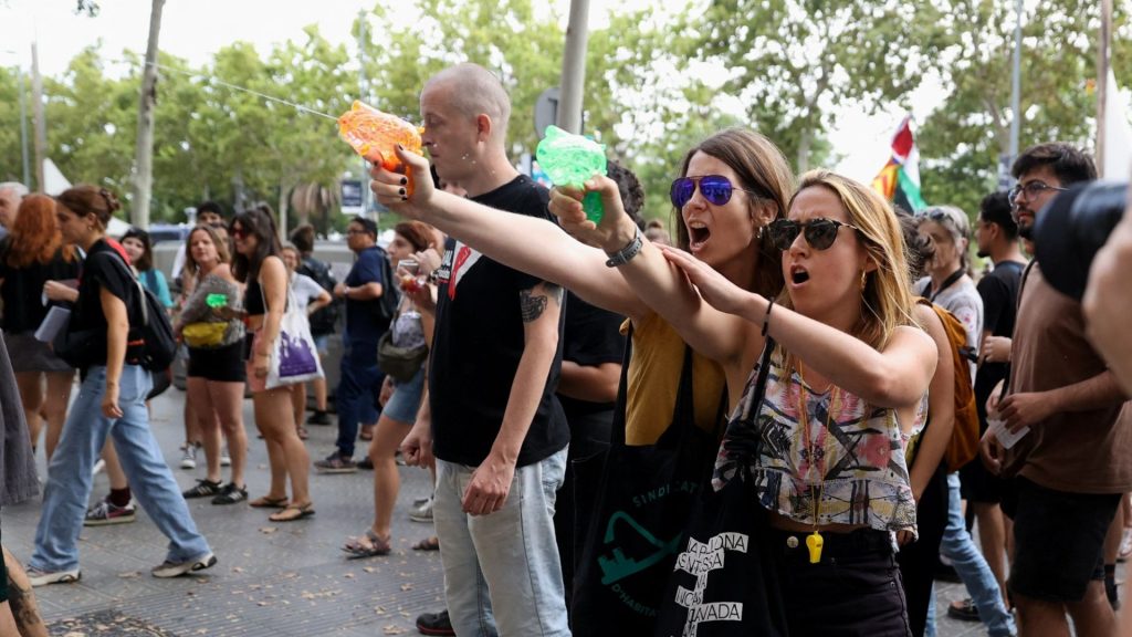 Anti-tourist protesters blast foreigners with WATER PISTOLS in march through Barcelona telling visitors to ‘go home’ – The Sun